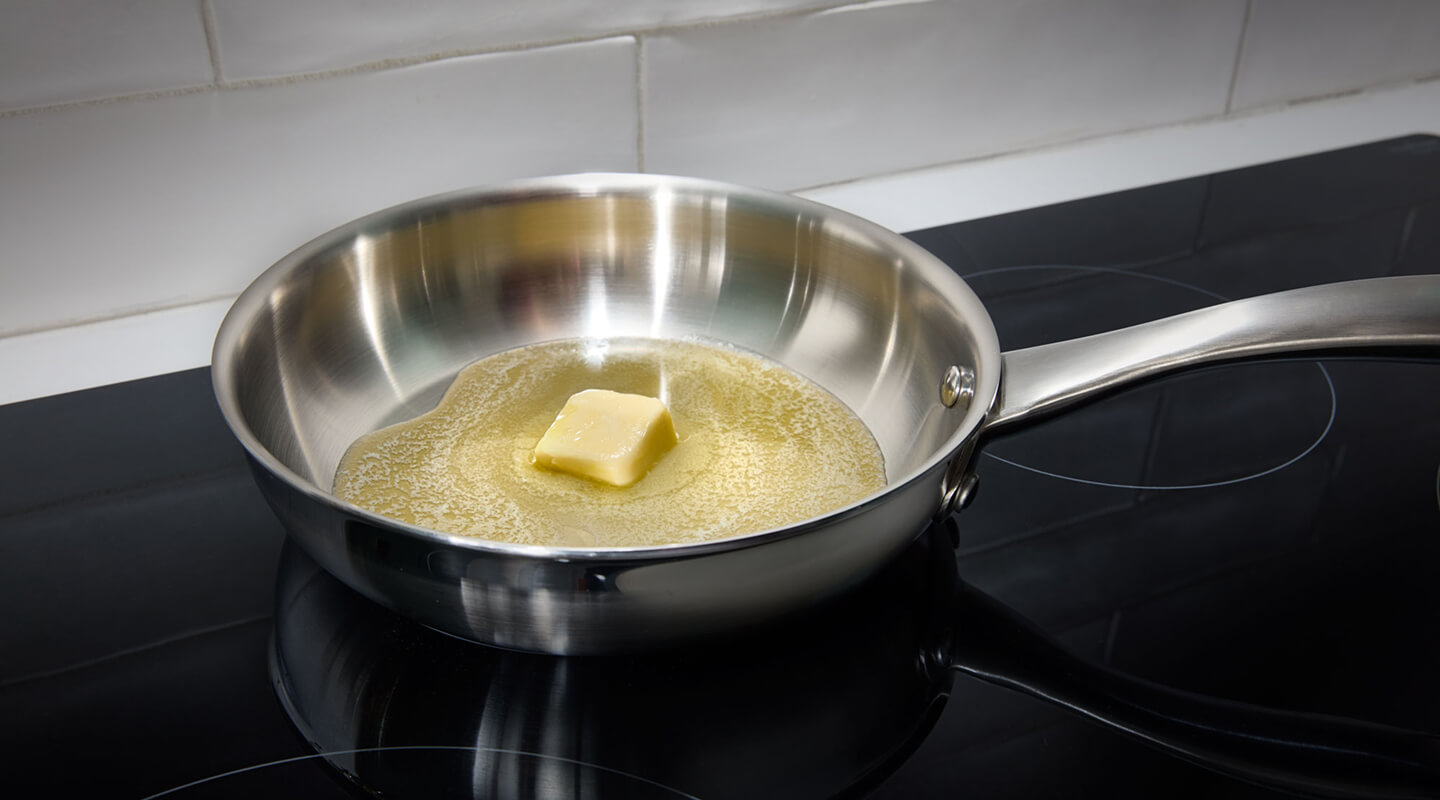 Butter melting in a pan on a cooktop