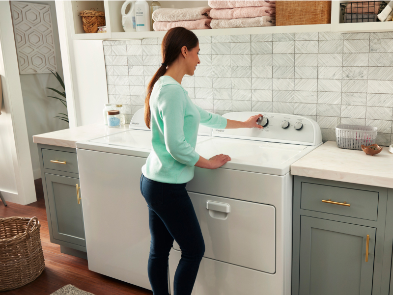 Person turning knob on dryer Person turning knob on dryer