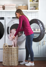 Person loading laundry into a dryer