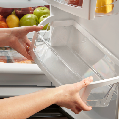 Pair of hands removing a refrigerator shelf