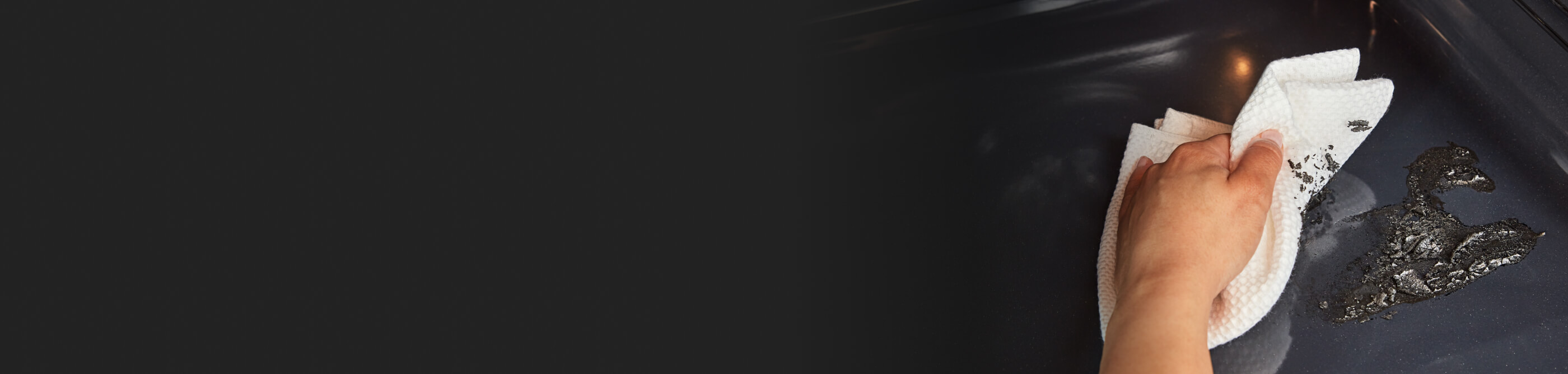 A hand wiping the inside of an oven