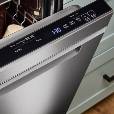 Close-up of a top control dishwasher door propped open