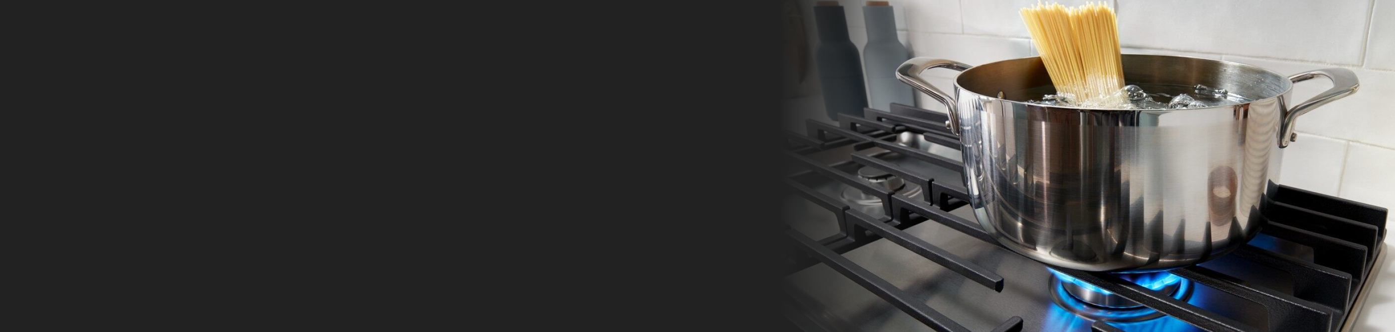 A pot resting on gas stove burner grates.