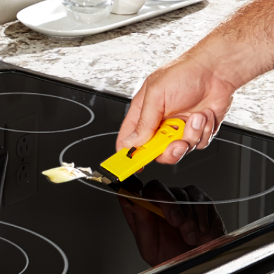 Person scraping a Whirlpool® induction cooktop