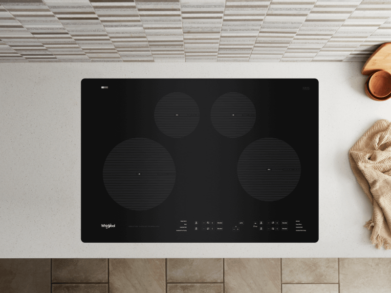 Birds-eye view of an induction stovetop built into a white countertop Birds-eye view of an induction stovetop built into a white countertop