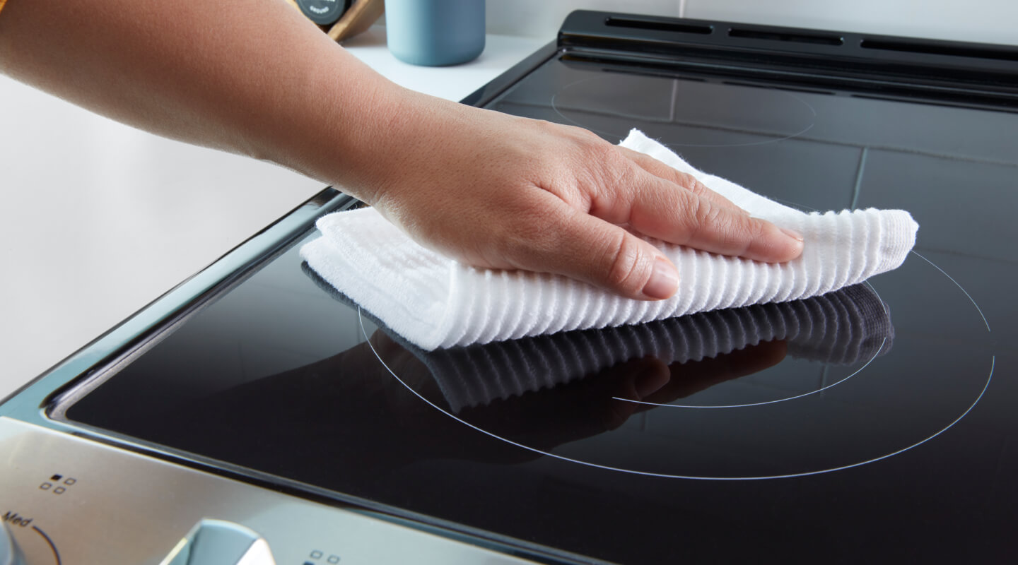 Person wiping electric stovetop