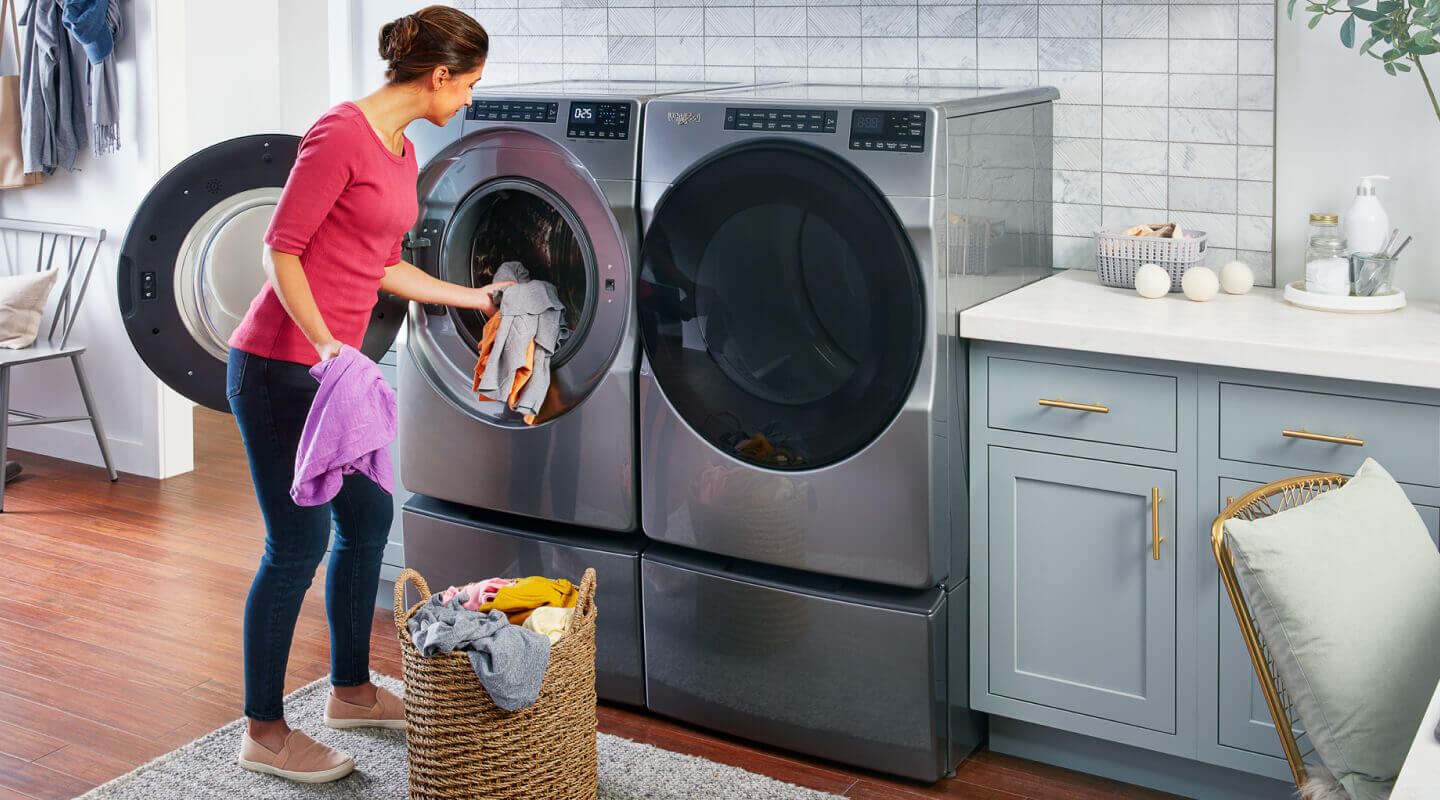 Person putting clothes in the washing machine Person putting clothes in the washing machine