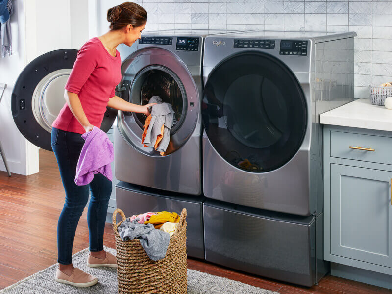Person putting clothes in the washing machine Person putting clothes in the washing machine