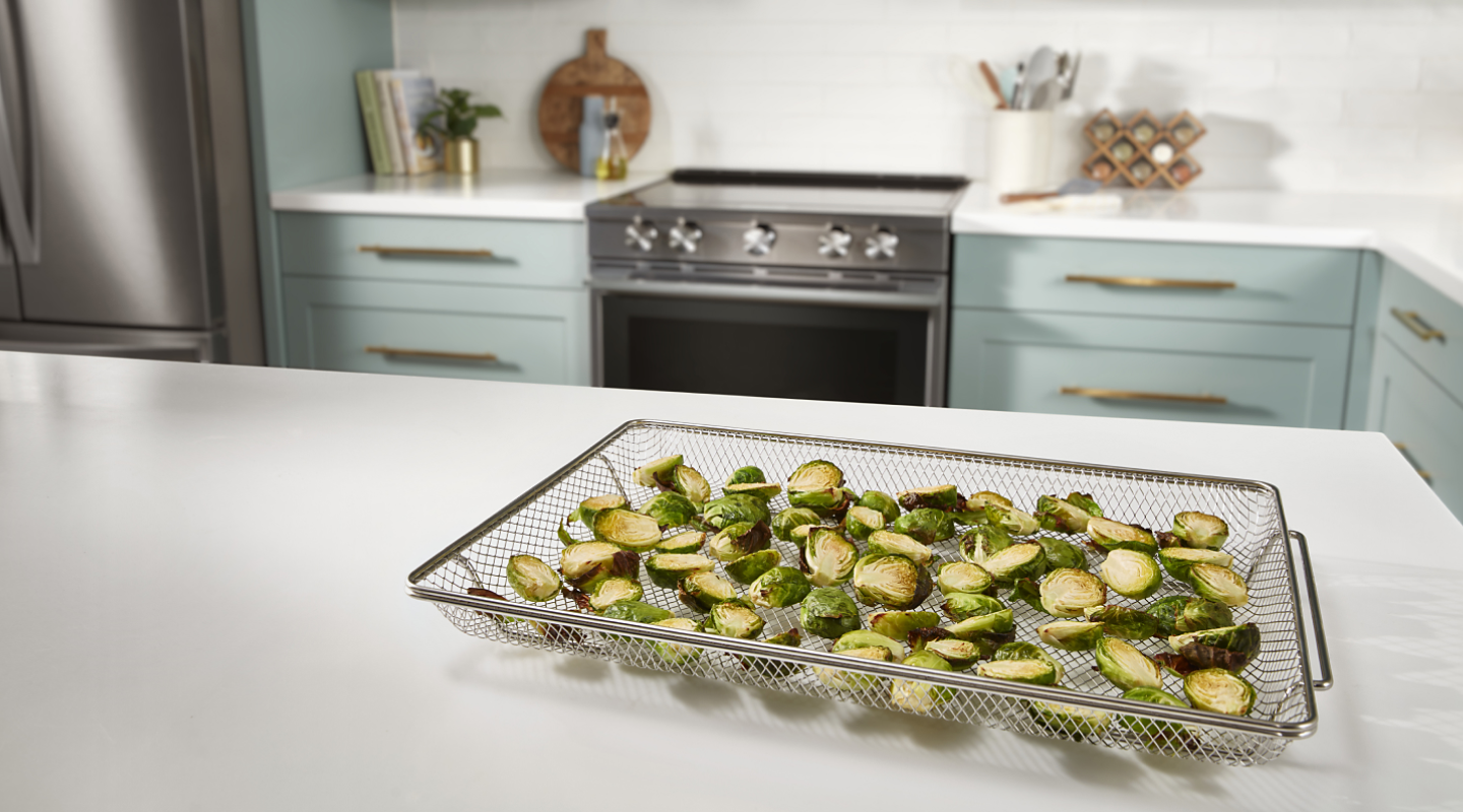 Sliced Brussels sprouts inside an air fryer basket Sliced Brussels sprouts inside an air fryer basket