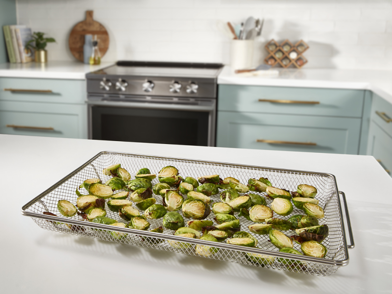 Sliced Brussels sprouts inside an air fryer basket Sliced Brussels sprouts inside an air fryer basket