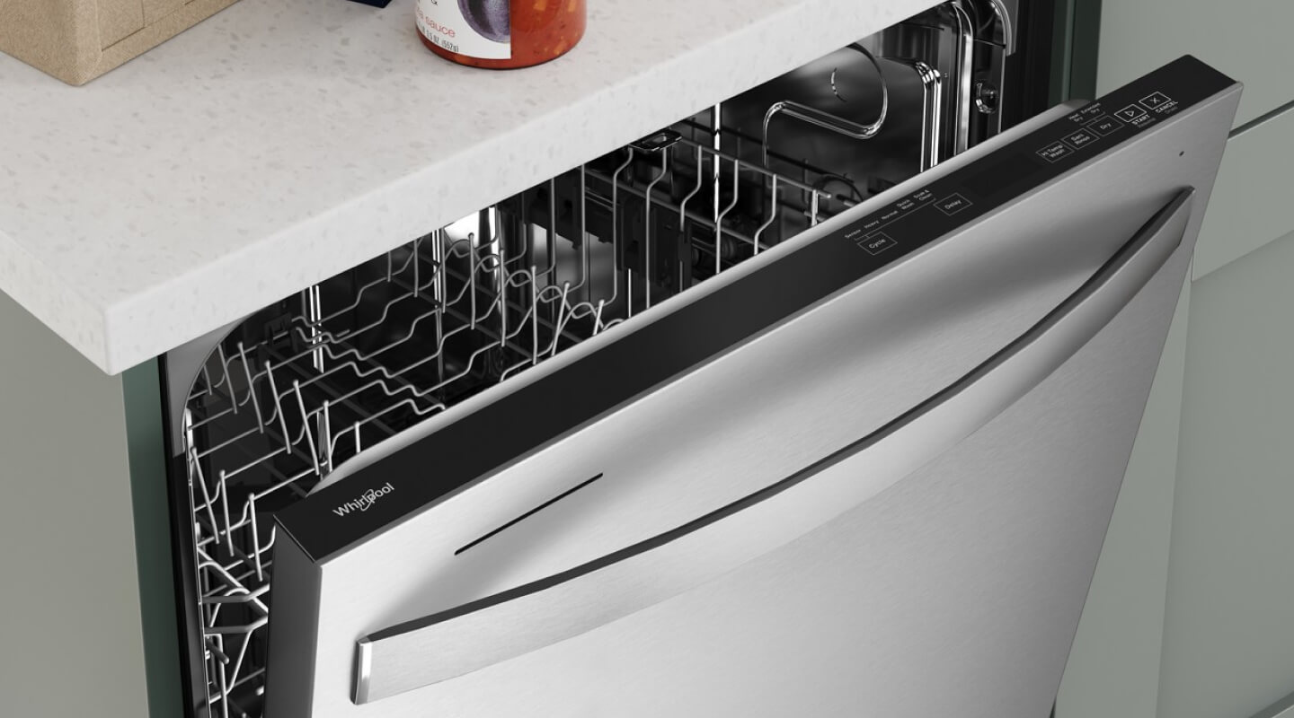 An aerial view of a Whirlpool® dishwasher opened just enough to see the top rack