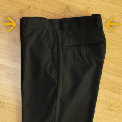 Creased pants folded in half with arrows facing inward