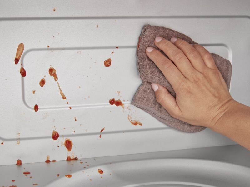 Person wiping the inside of the microwave