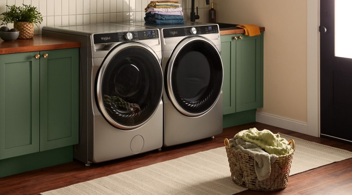 Stainless steel Whirlpool® Washer and Dryer set in green laundry room cabinetry