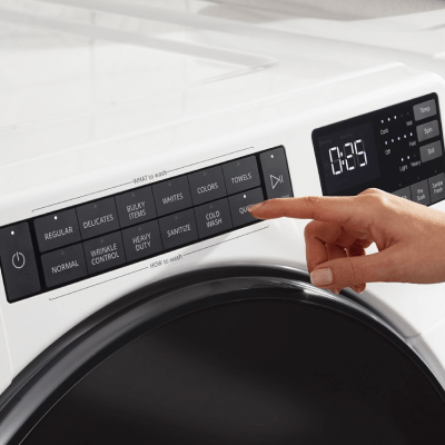 Person selecting settings on front load washer