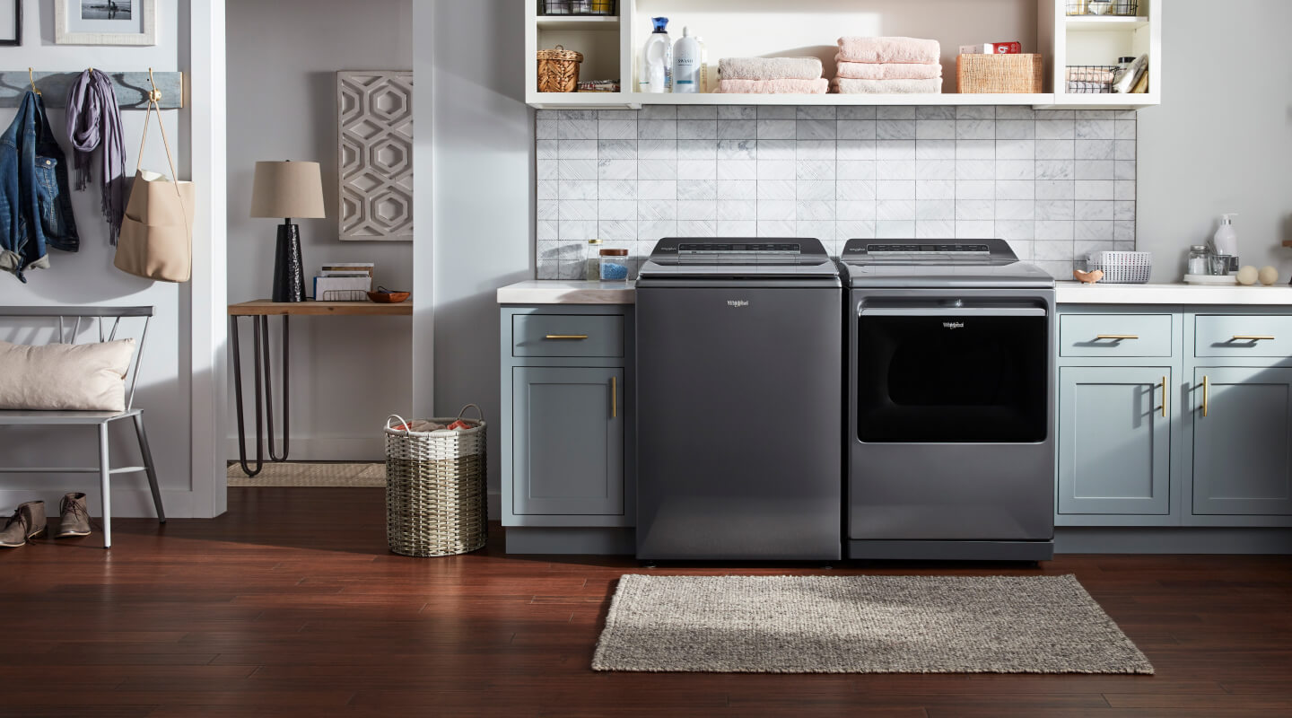 The inside of a tidy laundry room with a Whirlpool® washer and dryer next to each other