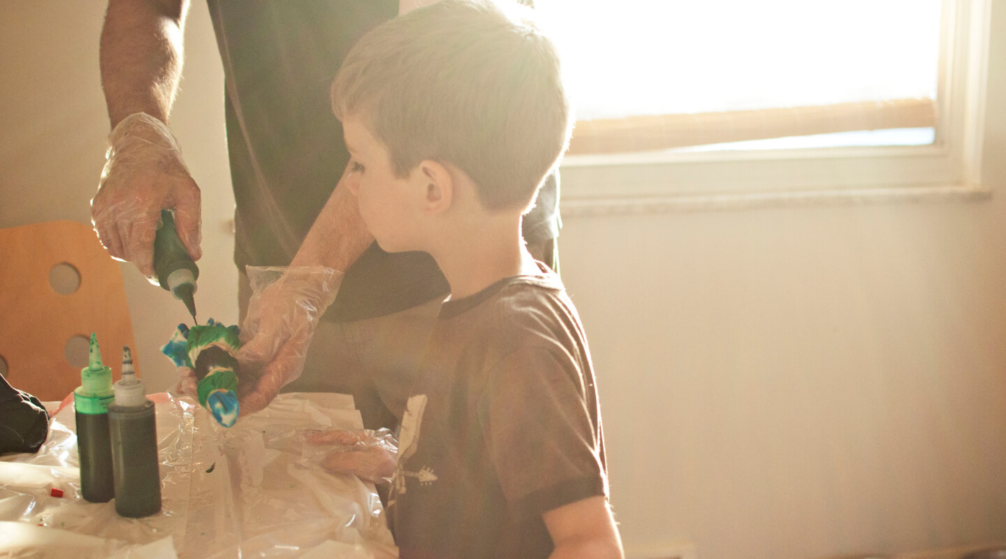 An adult and child crafting with paints An adult and child crafting with paints
