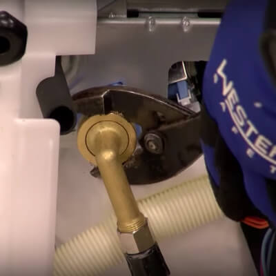 A close up of a wrench and water supply line