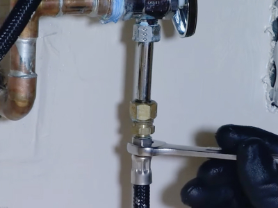 A person tightening a water valve