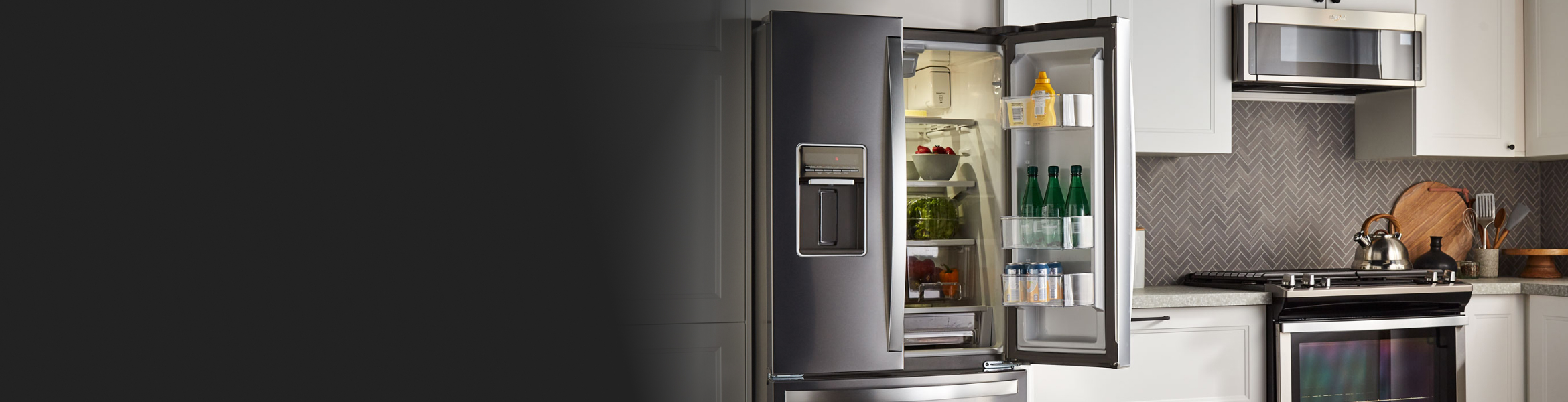 An open French Door refrigerator in a kitchen with white cabinets