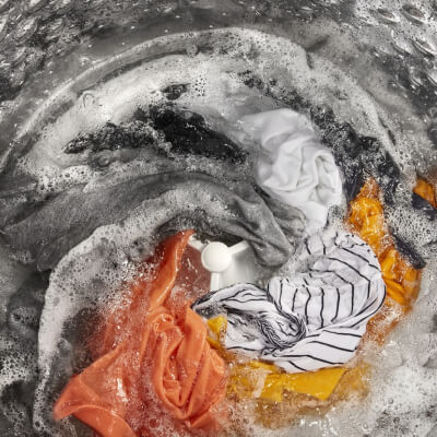 Clothes soaking in soapy water inside of a washer