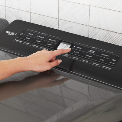 Person selecting cycle settings on a dryer