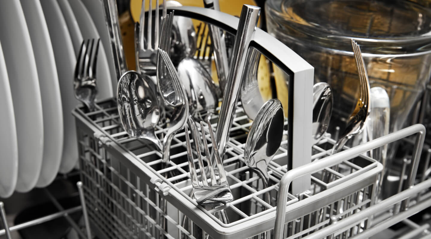 A close-up image of silverware loaded in a silverware basket