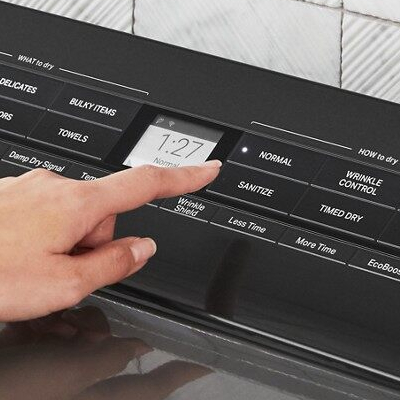 A person selecting dryer settings.