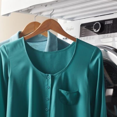 A teal blouse air drying on a hanger.