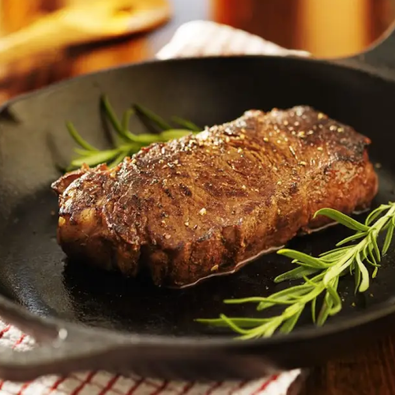 Pan seared steak in a cast iron skillet with garnish