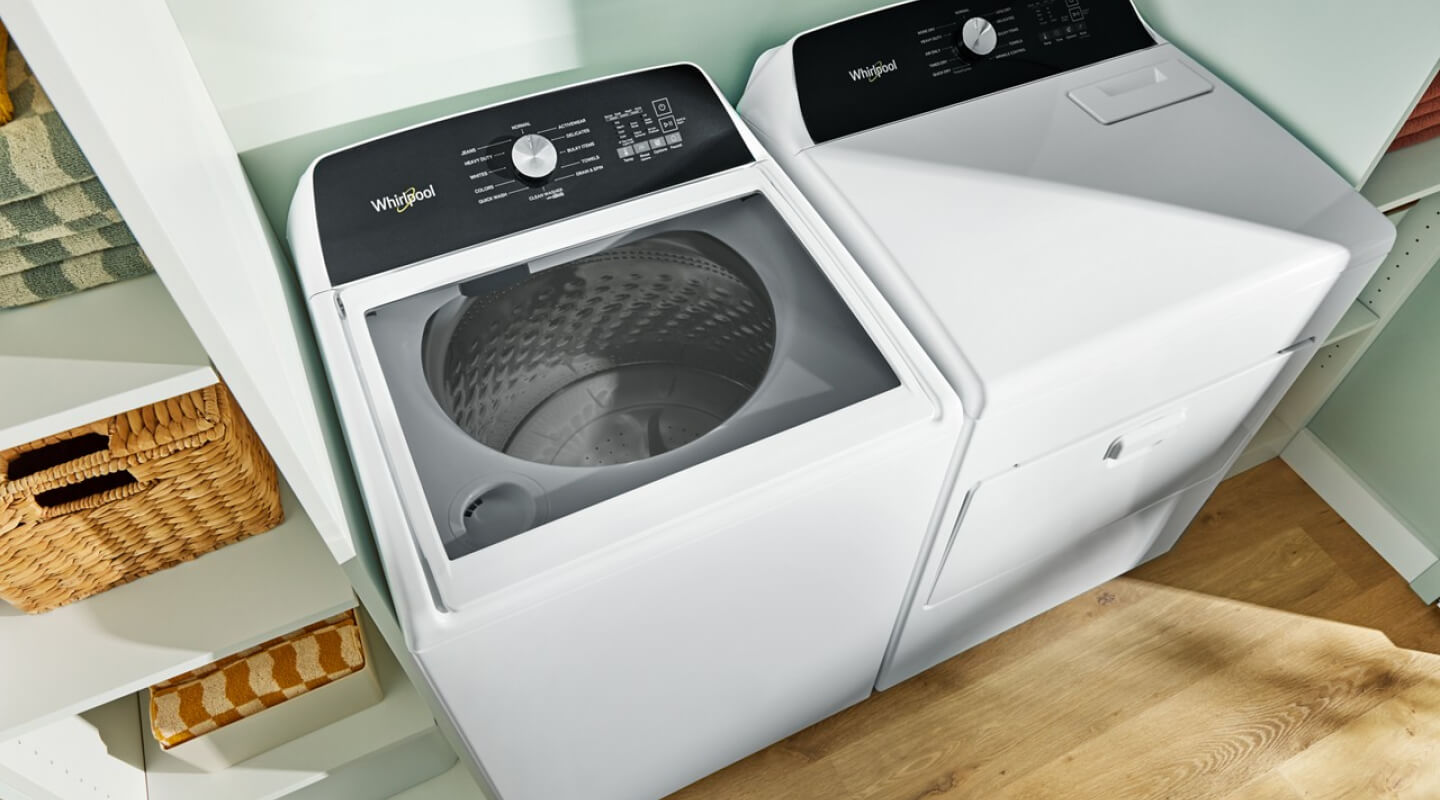 A laundry area with a Whirlpool® Top-Load Washer and Dryer