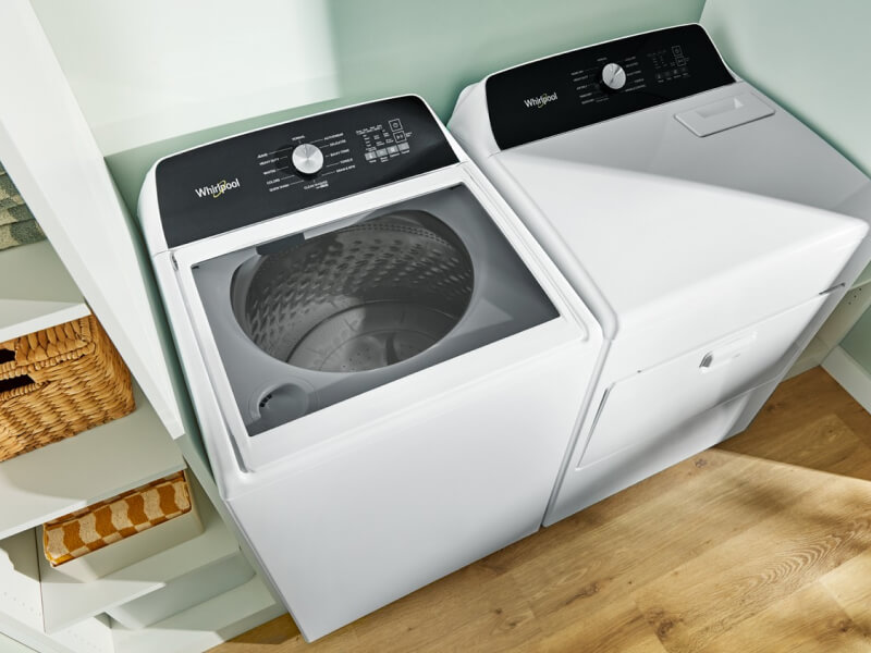 A laundry area with a Whirlpool® Top-Load Washer and Dryer