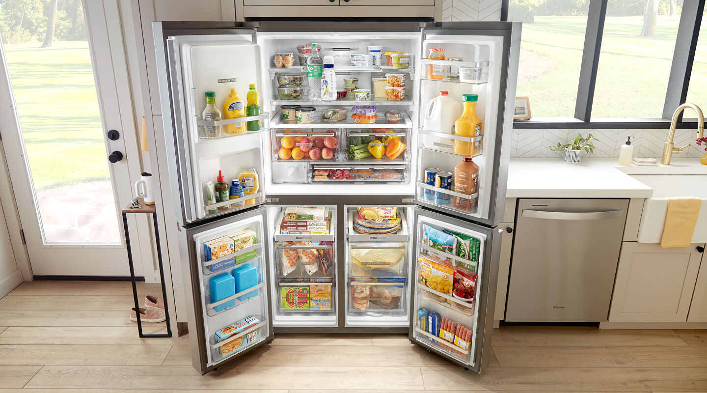 A 4 door refrigerator with all doors open in a bright kitchen