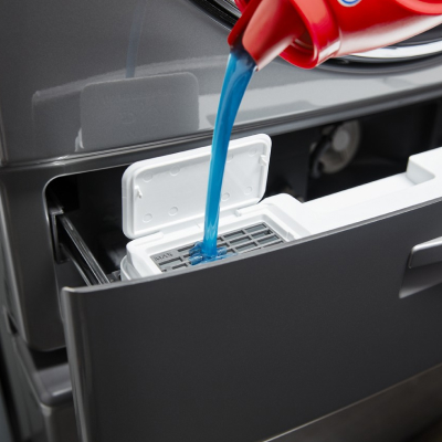 Detergent being poured into a dispenser