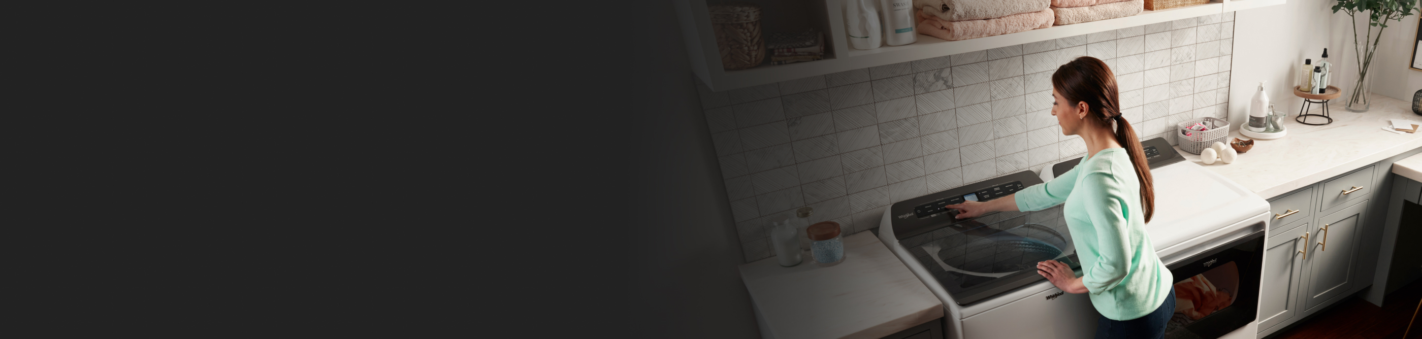 A woman selects a cycle on a top load washer