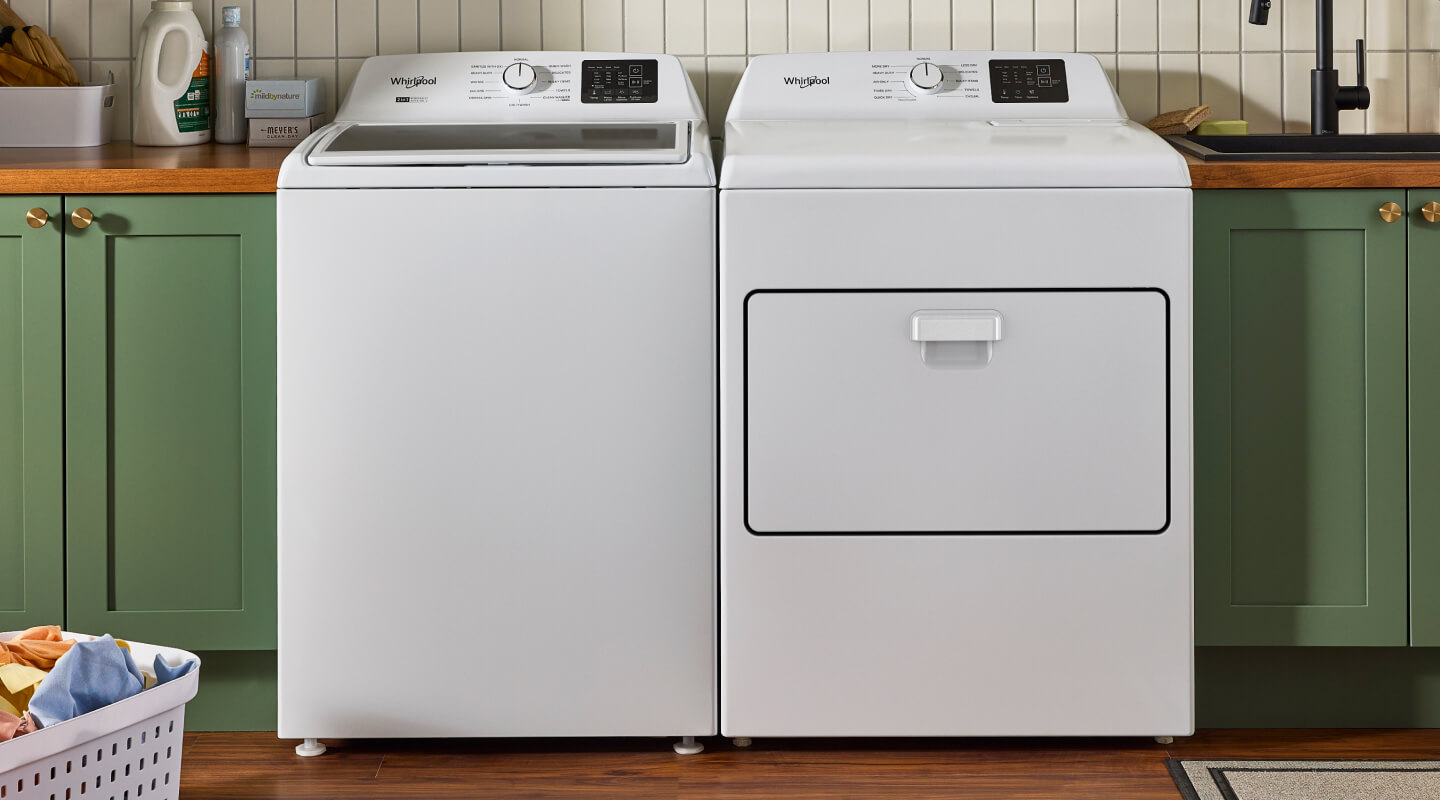  A white Whirlpool® washer and dryer in a laundry room with green cabinetry