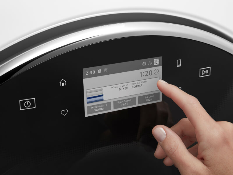 Person about to select something on a washing machine digital panel