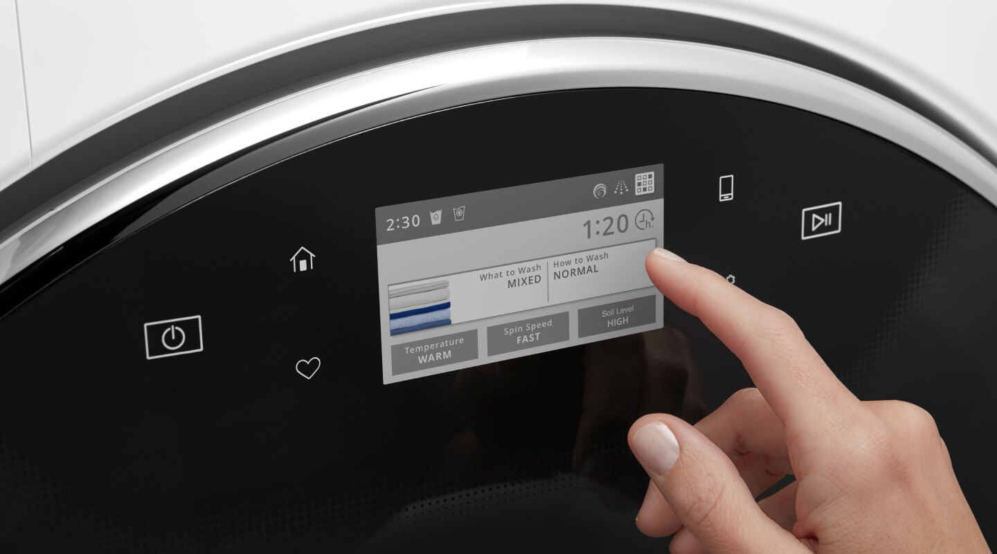 Person about to select something on a washing machine digital panel