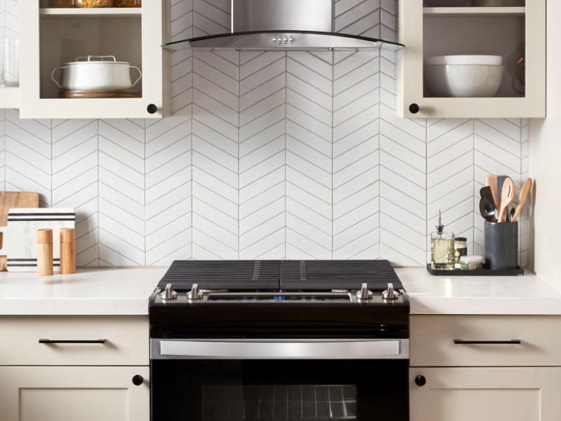 A black range and range hood in a modern kitchen A black range and range hood in a modern kitchen