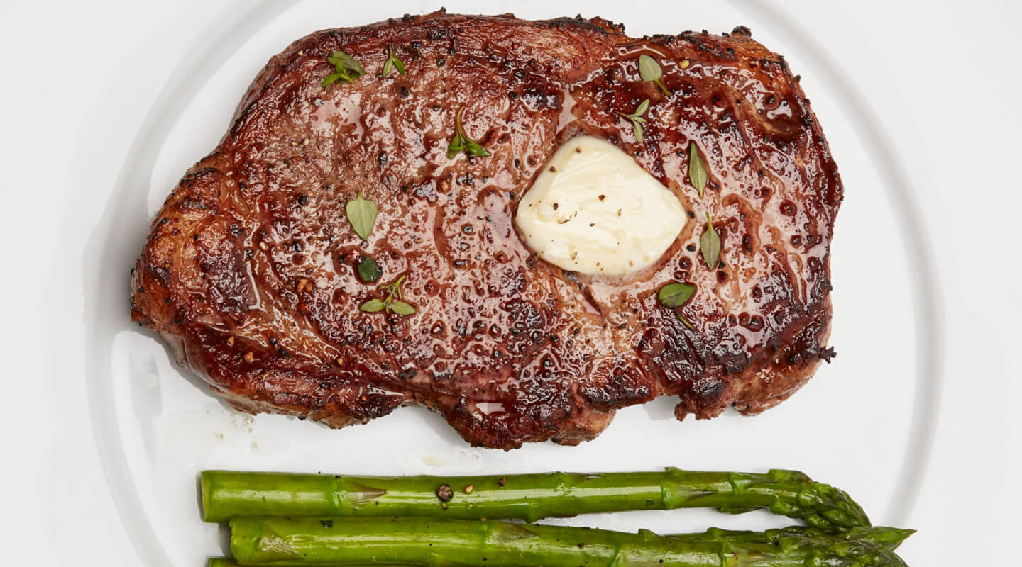 A seared steak with butter and roasted asparagus A seared steak with butter and roasted asparagus