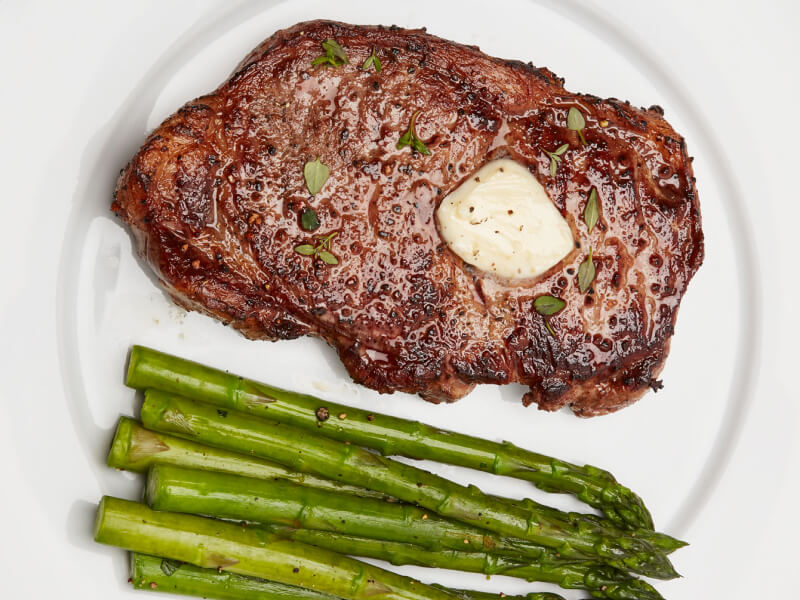 A seared steak with butter and roasted asparagus A seared steak with butter and roasted asparagus