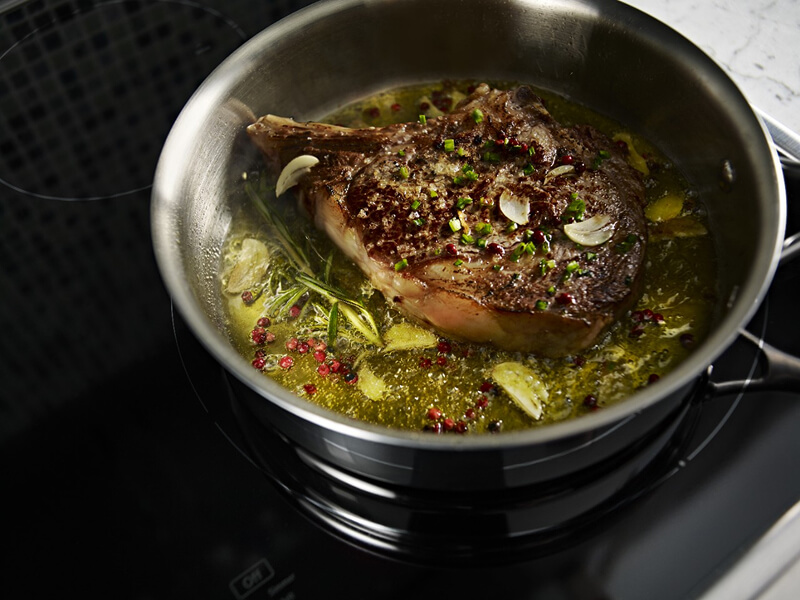 A large piece of meat, simmering in a pot A large piece of meat, simmering in a pot