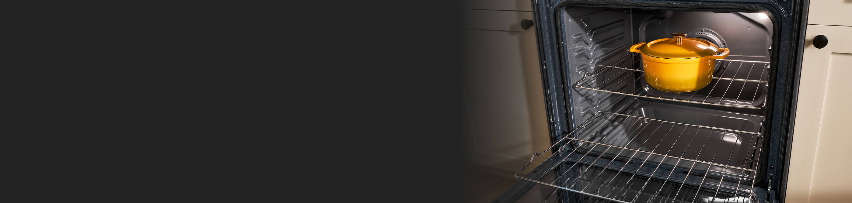 A yellow, slow cooking pot inside an oven