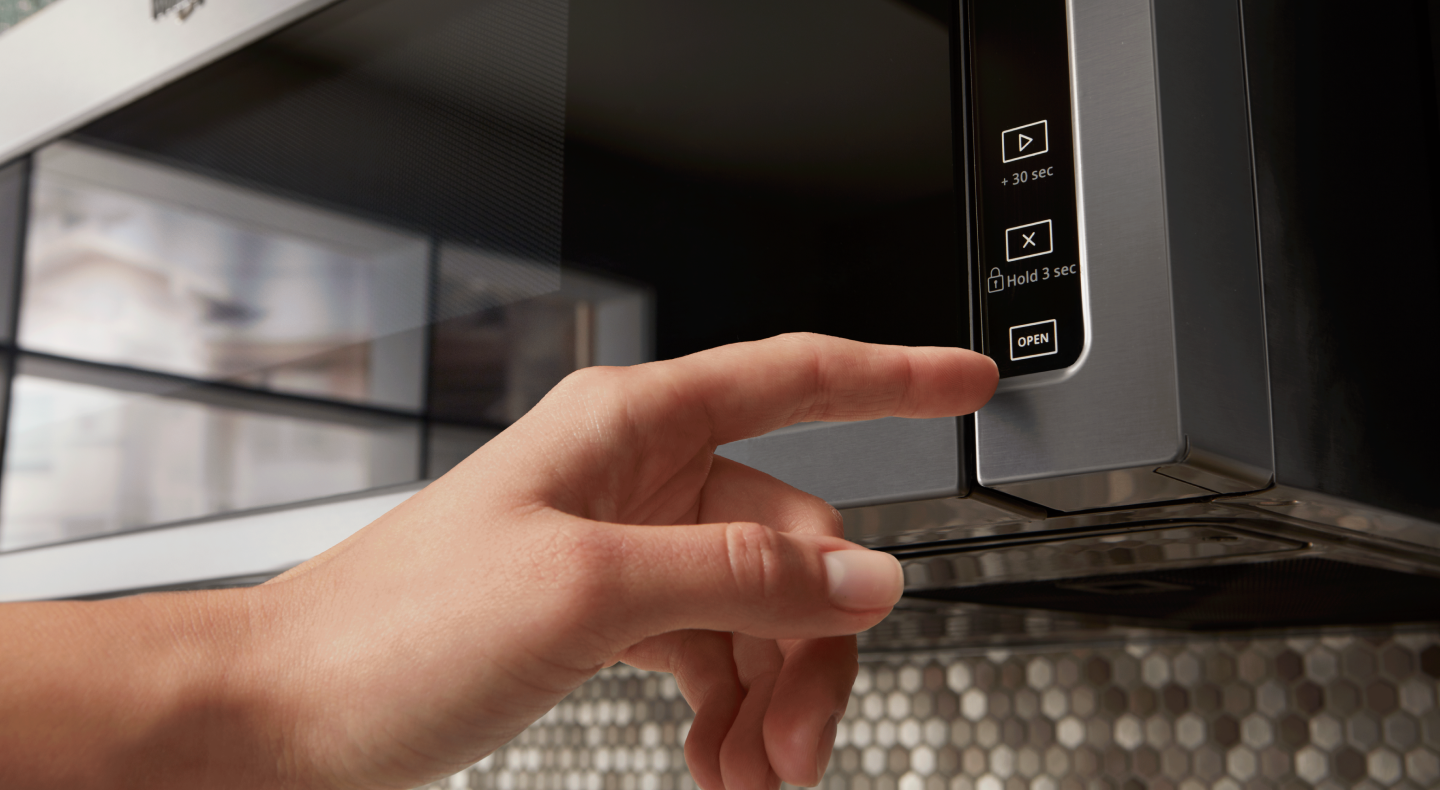 Hand making a selection on the microwave