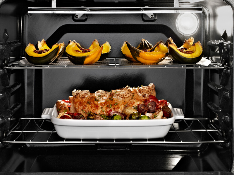 Oven open with cooked food on both racks