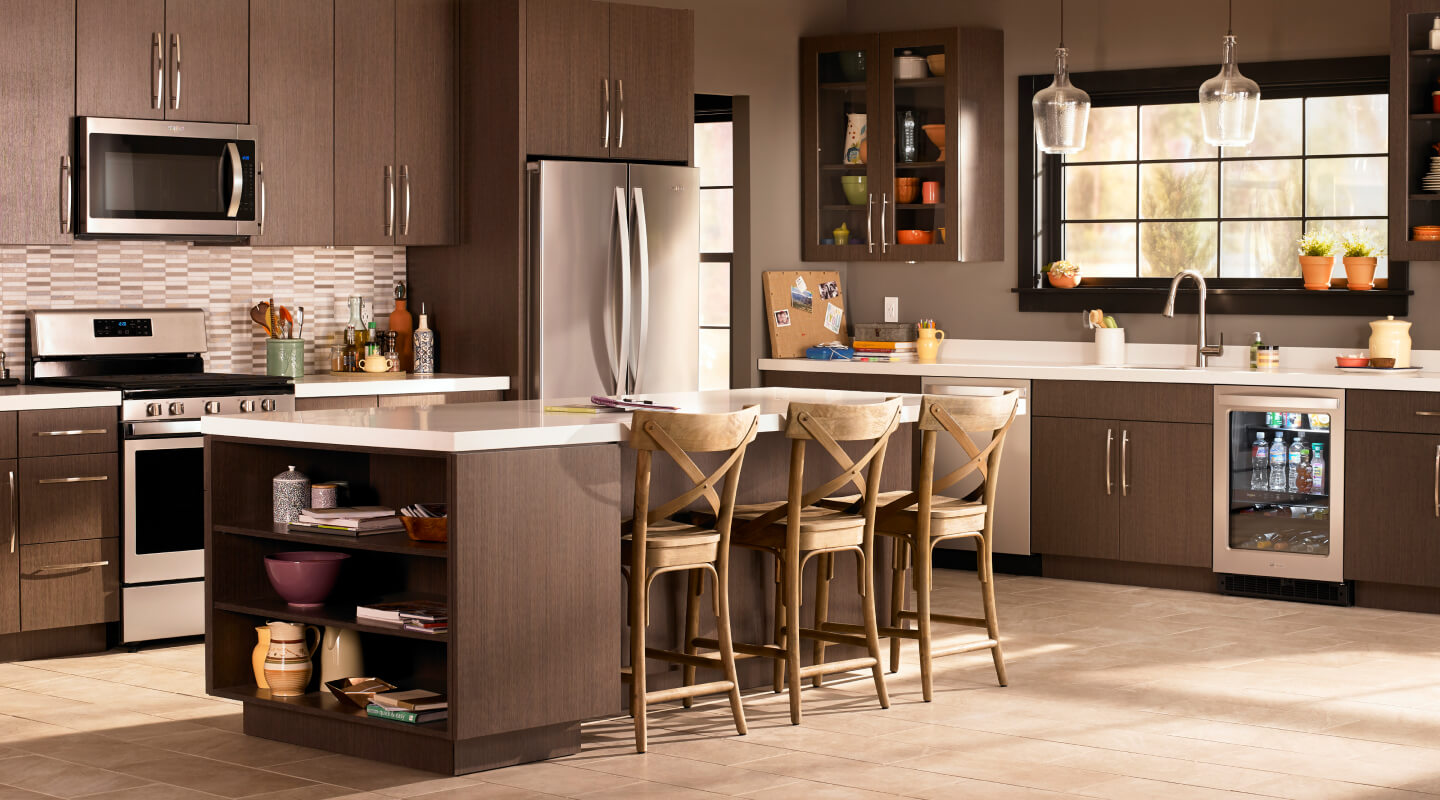 A kitchen with brown cabinets and stainless steel Whirlpool® appliances A kitchen with brown cabinets and stainless steel Whirlpool® appliances