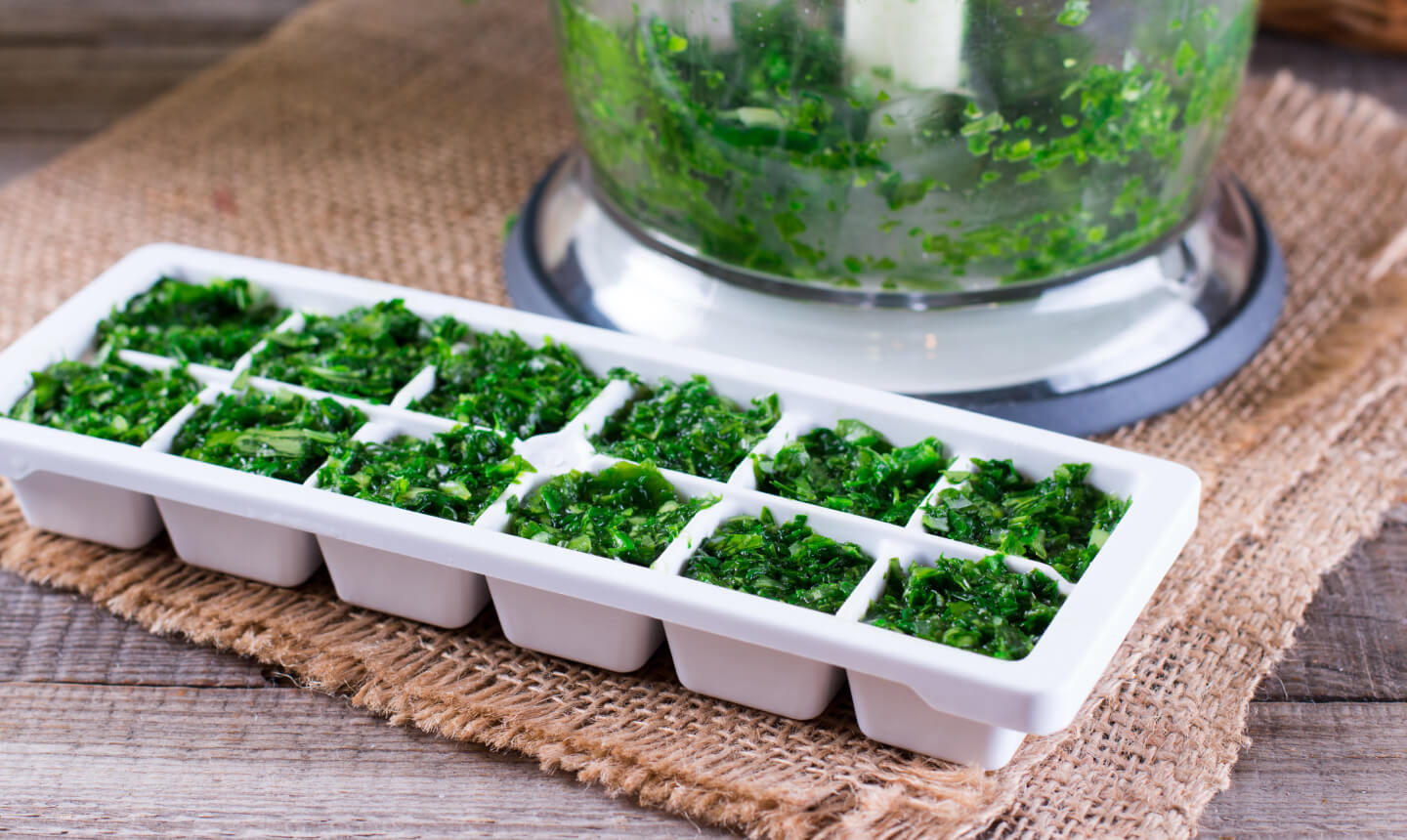 Chopped herbs in a white ice tray 