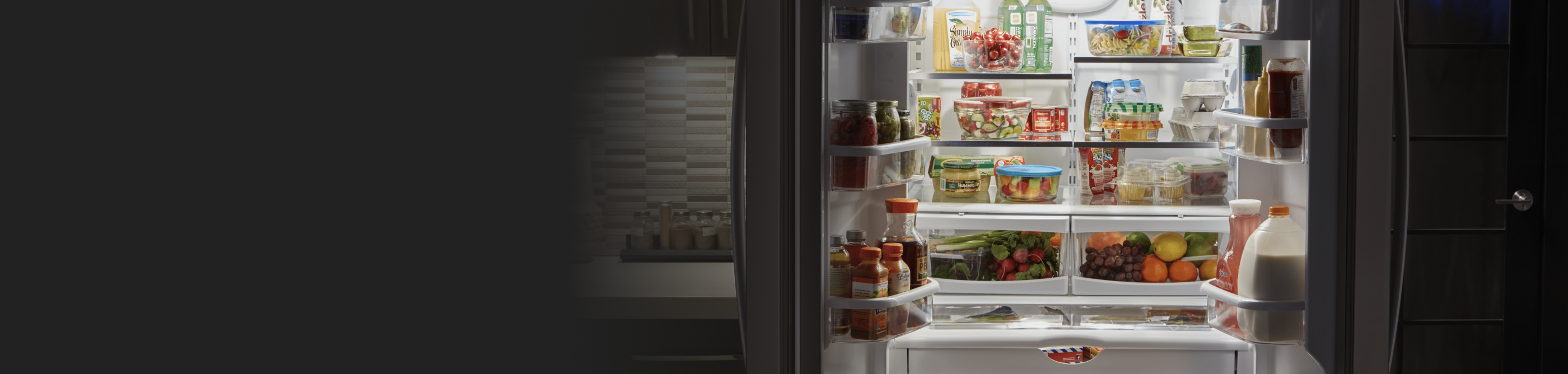 Open refrigerator full of fresh produce and groceries