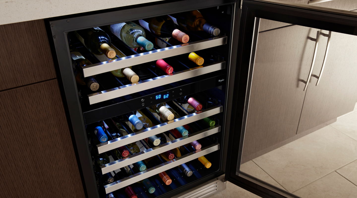 Wine bottles stored on the various levels of a wine fridge Wine bottles stored on the various levels of a wine fridge