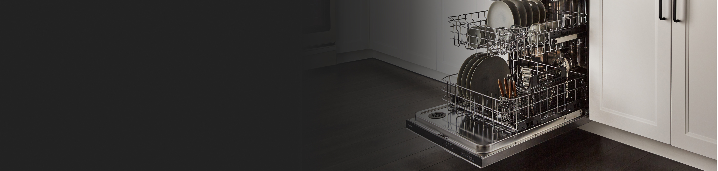 An open Whirlpool® dishwasher loaded with dishes.